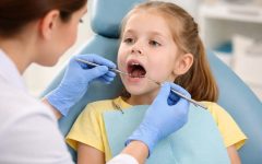 Ребёнок на осмотре у стоматолога во время проверки молочных зубов