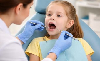 Ребёнок на осмотре у стоматолога во время проверки молочных зубов